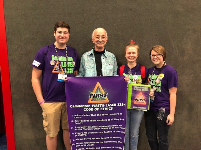 Students from LASER 3284 show the team's Code of Ethics to Dr. Woodie Flowers, FIRST Executive Advisory Board Co-Chair, Distinguished Advisor.” class=