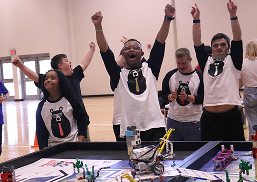 "The Dancing Bears" cheer after successfully completing a mission during the Robot Challenge.