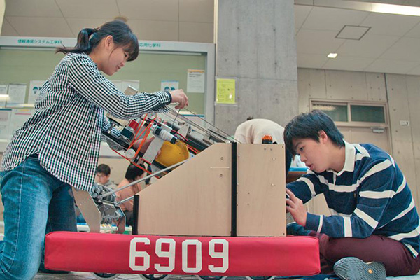 Kanon (left) and a student work on Sakura Tempesta’s robot